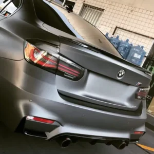 Vista de um belo BMW 320i F30 2012-2018 envelopado em cinza fosco com Aerofolio BMW F30 Grid Parts